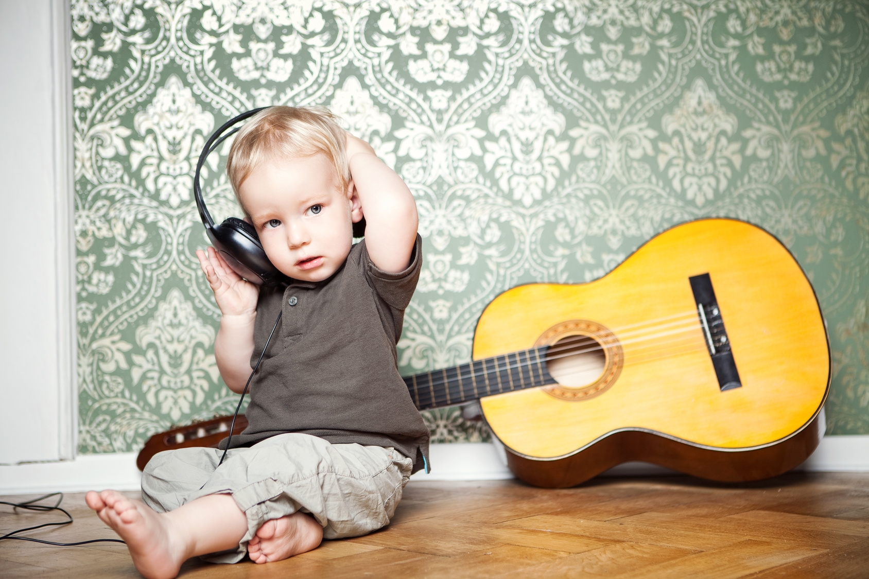 Junge mit Gitarre und Kopfhörern